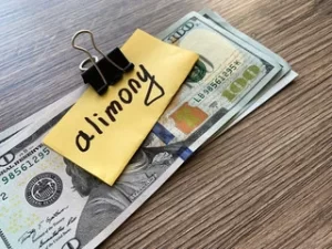 money clipped together with a post in note with the word alimony on it. 