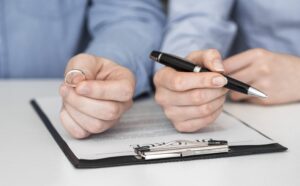 Immokalee Divorce Attorney close up couple signing divorce contract 300x186