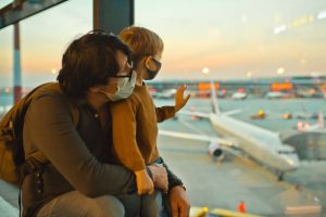 man and son looking out of the windows at the airport